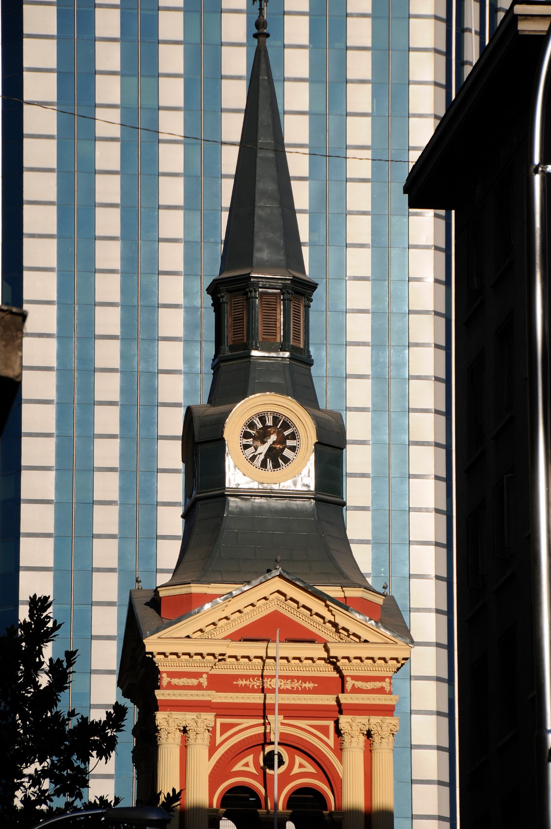 Chirch tower in front of a Skyscraper in Santiago de Chile